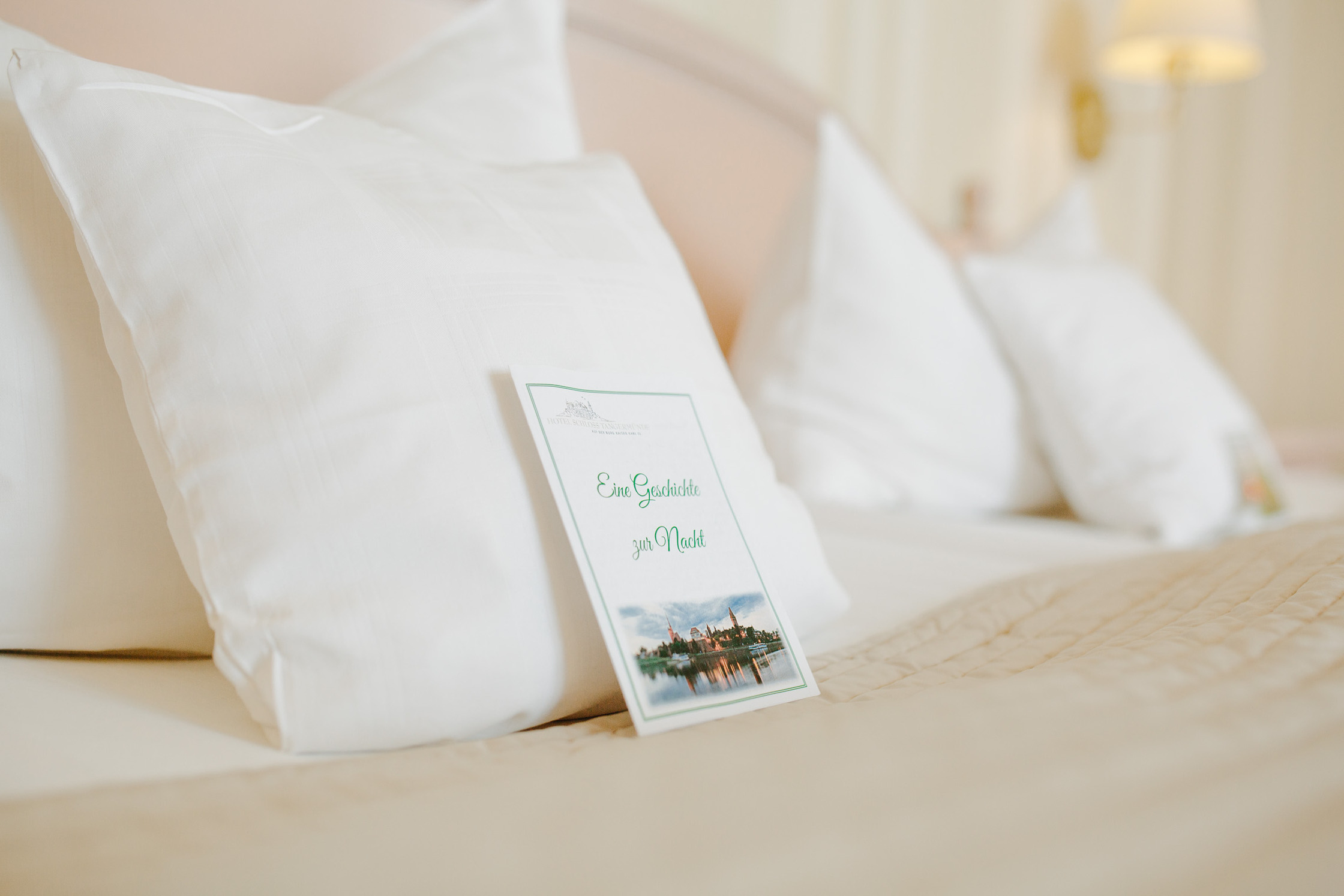 Hotelbett mit vier Kissen und Gute-Nacht-Geschichten des Hotel Schloss Tangermünde.