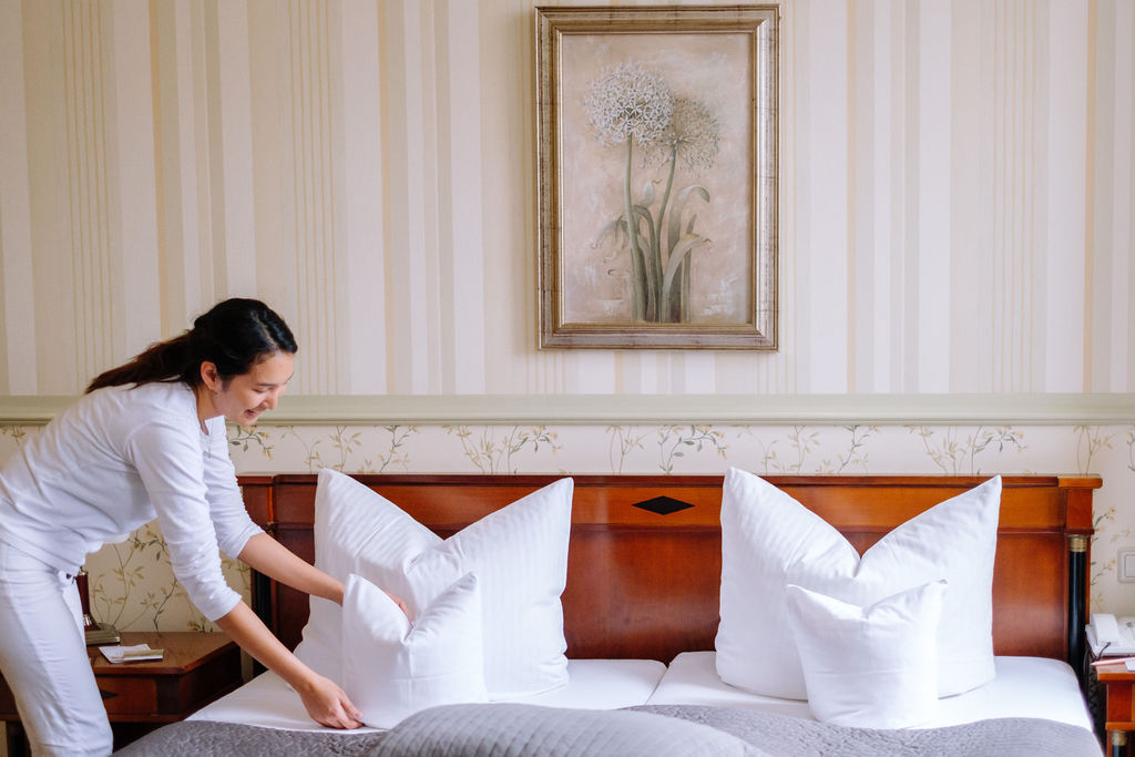 Zimmermädchen richtet ein Doppelzimmer im Haupthaus her.